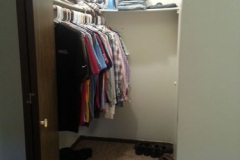 A closet with many shirts hanging on the wall.