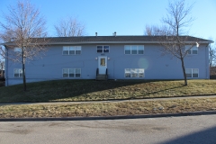 A large blue building with two windows and a door.