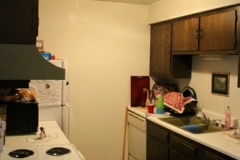 A kitchen with brown cabinets and white walls.
