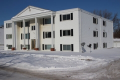 A white building with snow on the ground