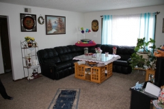 A living room with black leather furniture and a white table.