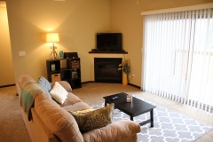 A living room with a couch, coffee table and television.
