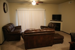 A living room with brown leather furniture and a flat screen tv.