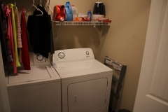 A washer and dryer in a room with shelves.
