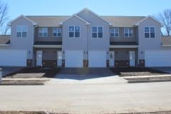 A row of houses with two garages in front.