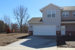 A white garage door in front of a house.