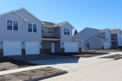 A row of houses with the driveway in front.
