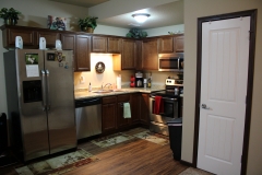 A kitchen with stainless steel appliances and wooden cabinets.