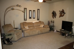 A living room with a couch and two mirrors