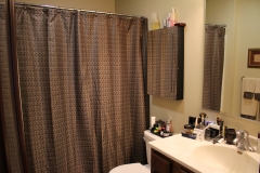 A bathroom with brown curtains and white toilet.